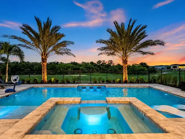 Private pool and spa overlooking palm trees at sunset